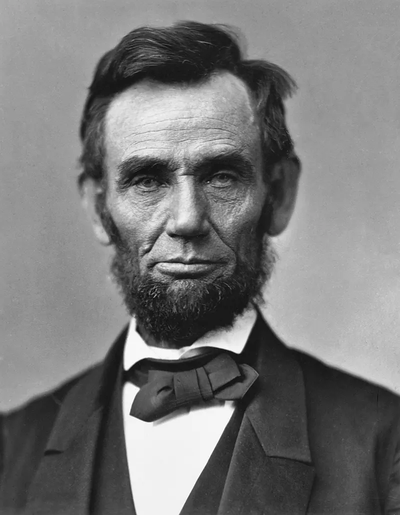 Black and white photo of a bearded man in a dark suit and bow tie