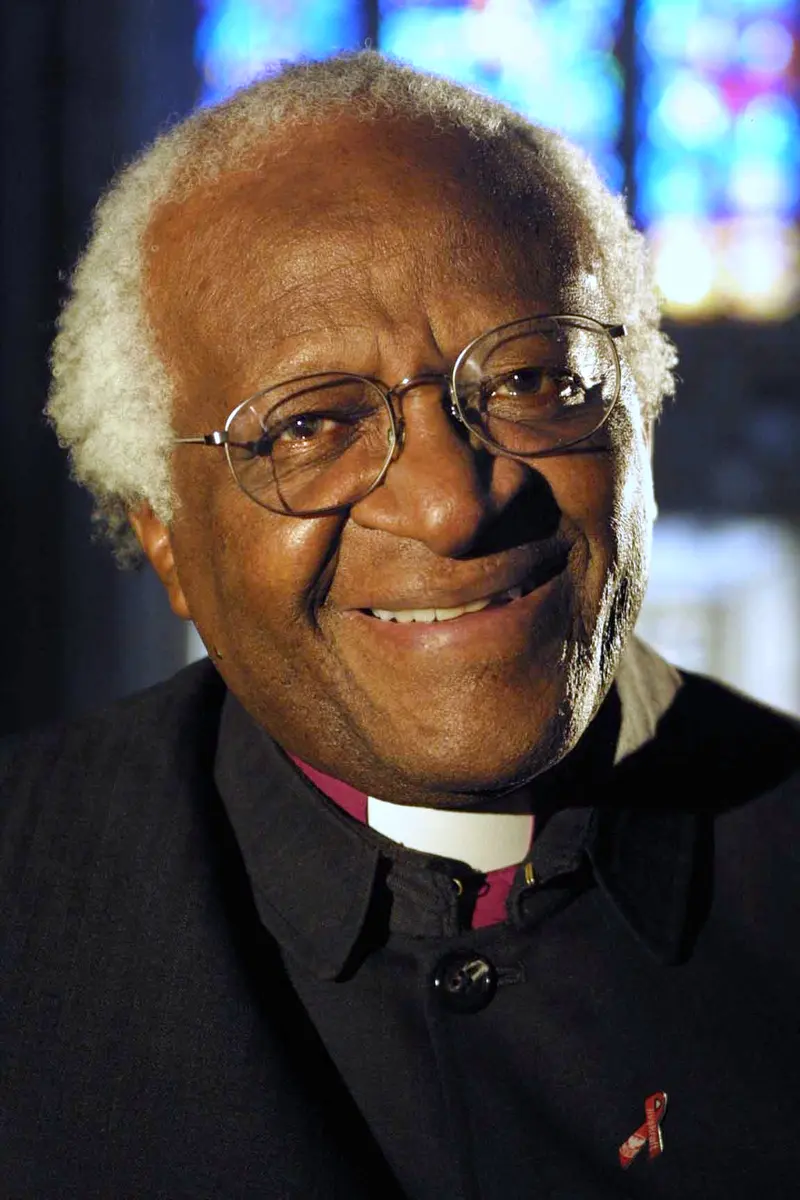 Photo of Archbishop Desmond Tutu smiling, wearing glasses and a dark shirt