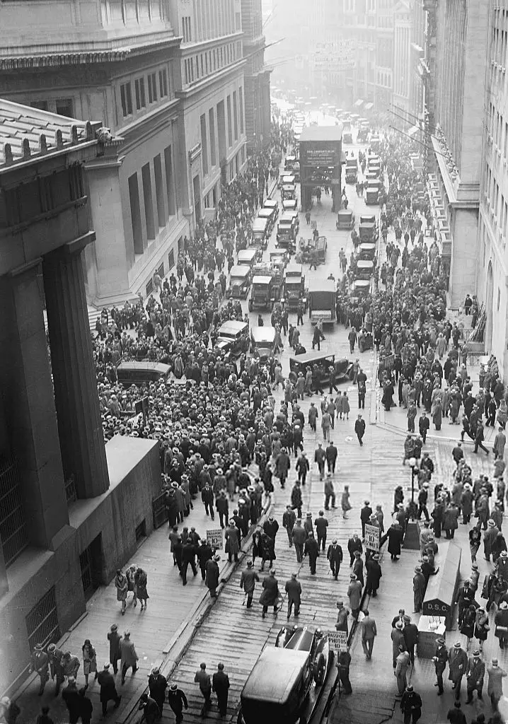 Black-and-white photo of a huge crowd filling Wall Street outside the New York Stock Exchange
